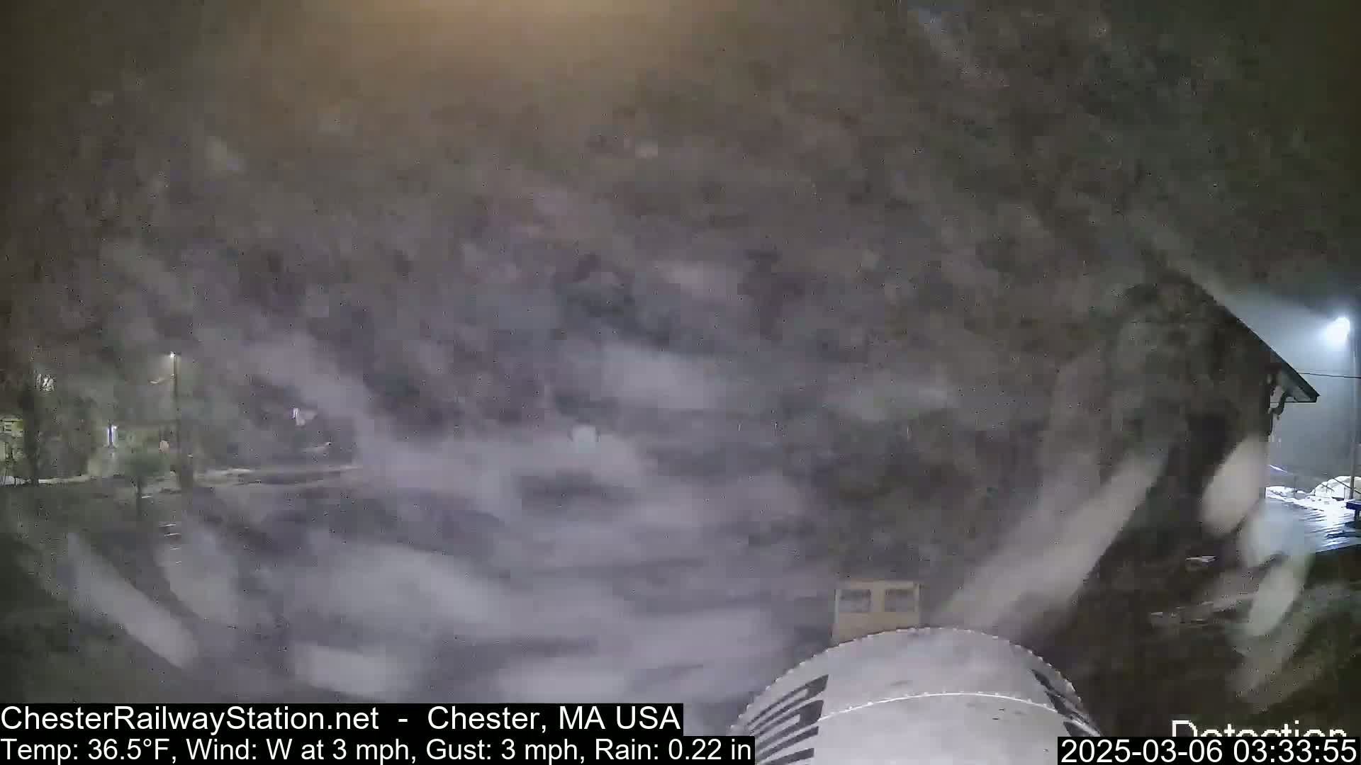 A nighttime scene of heavy rain and wind blowing around a building.