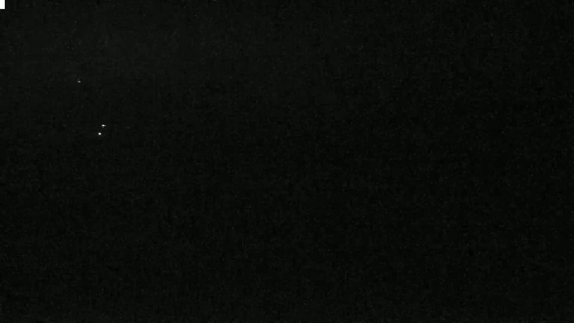 A dark, possibly nighttime, sky shows three faint points of light.