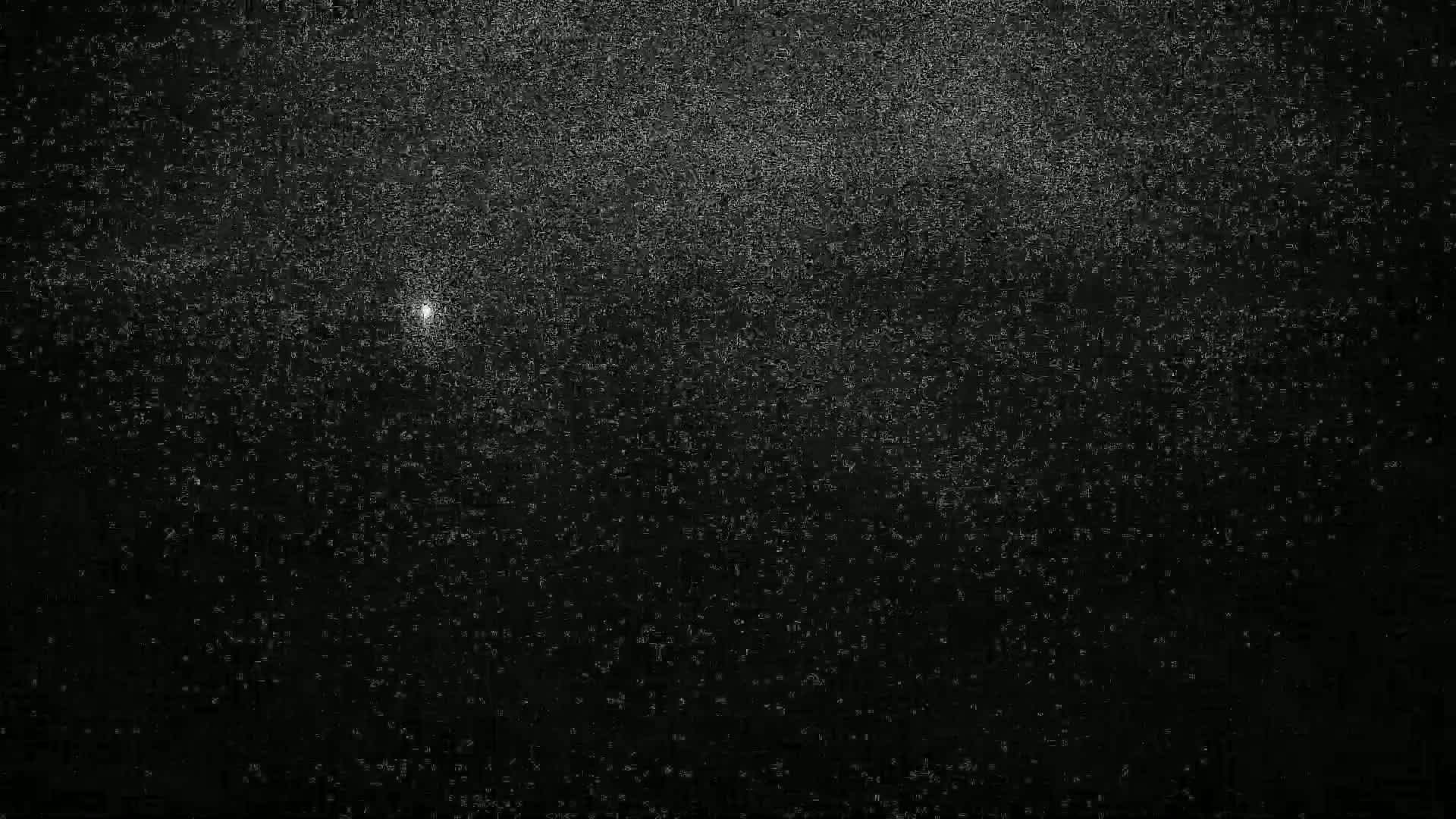 A bright point of light is visible in a dark, heavily speckled sky.