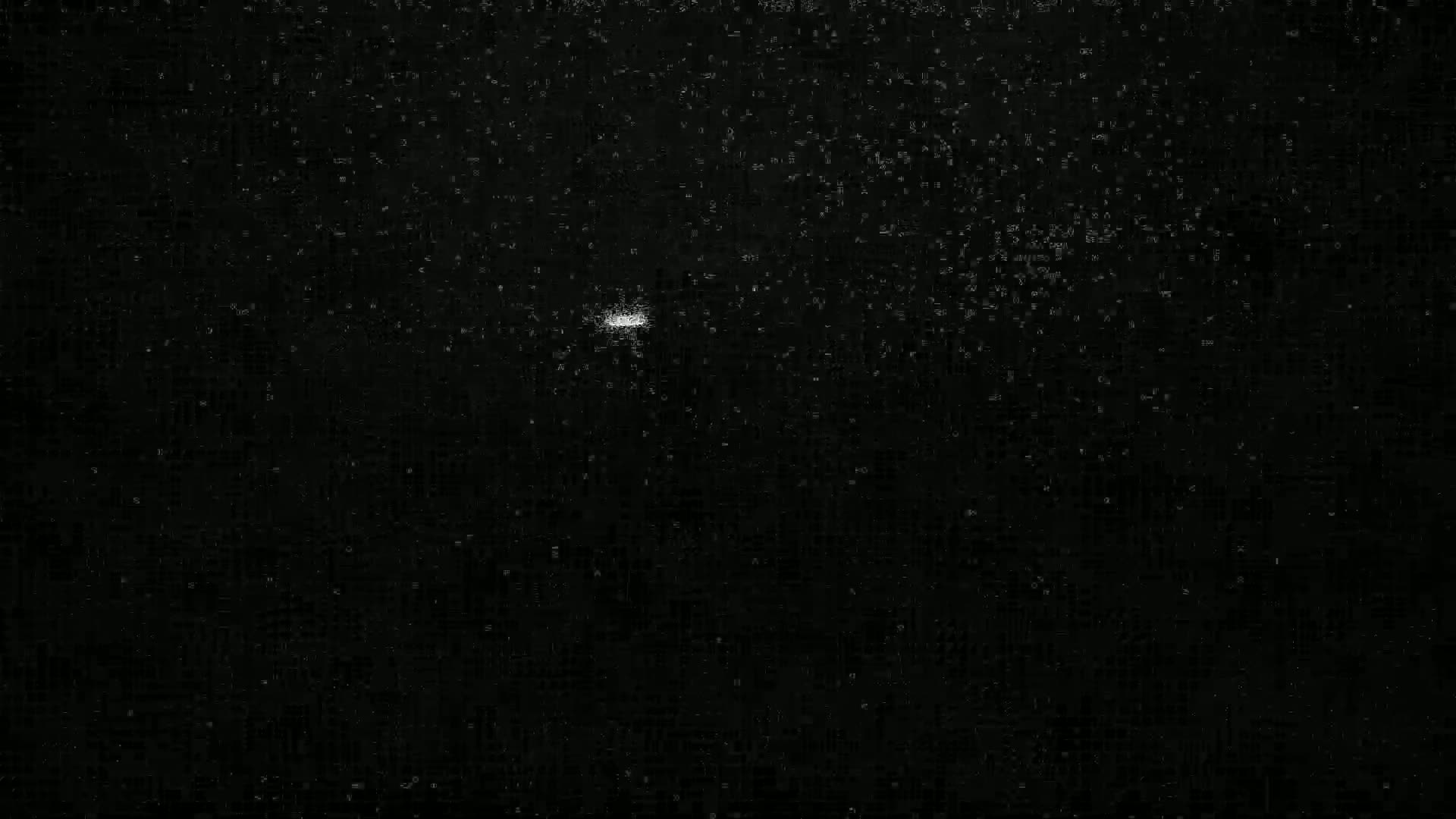 A single, faint, white light is visible against a completely dark, speckled background.