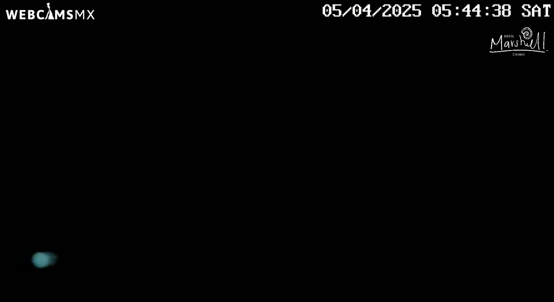 A small, faint light is visible in an otherwise completely dark nighttime scene.