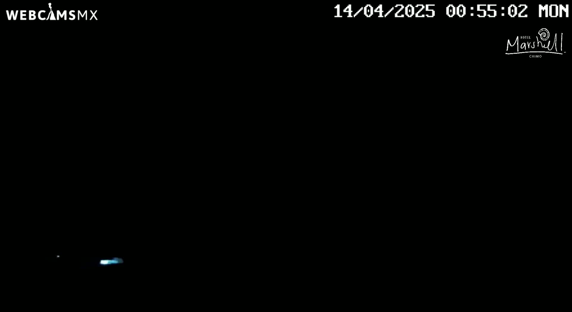 A nighttime image shows a faint, bluish light source near the bottom of the frame.