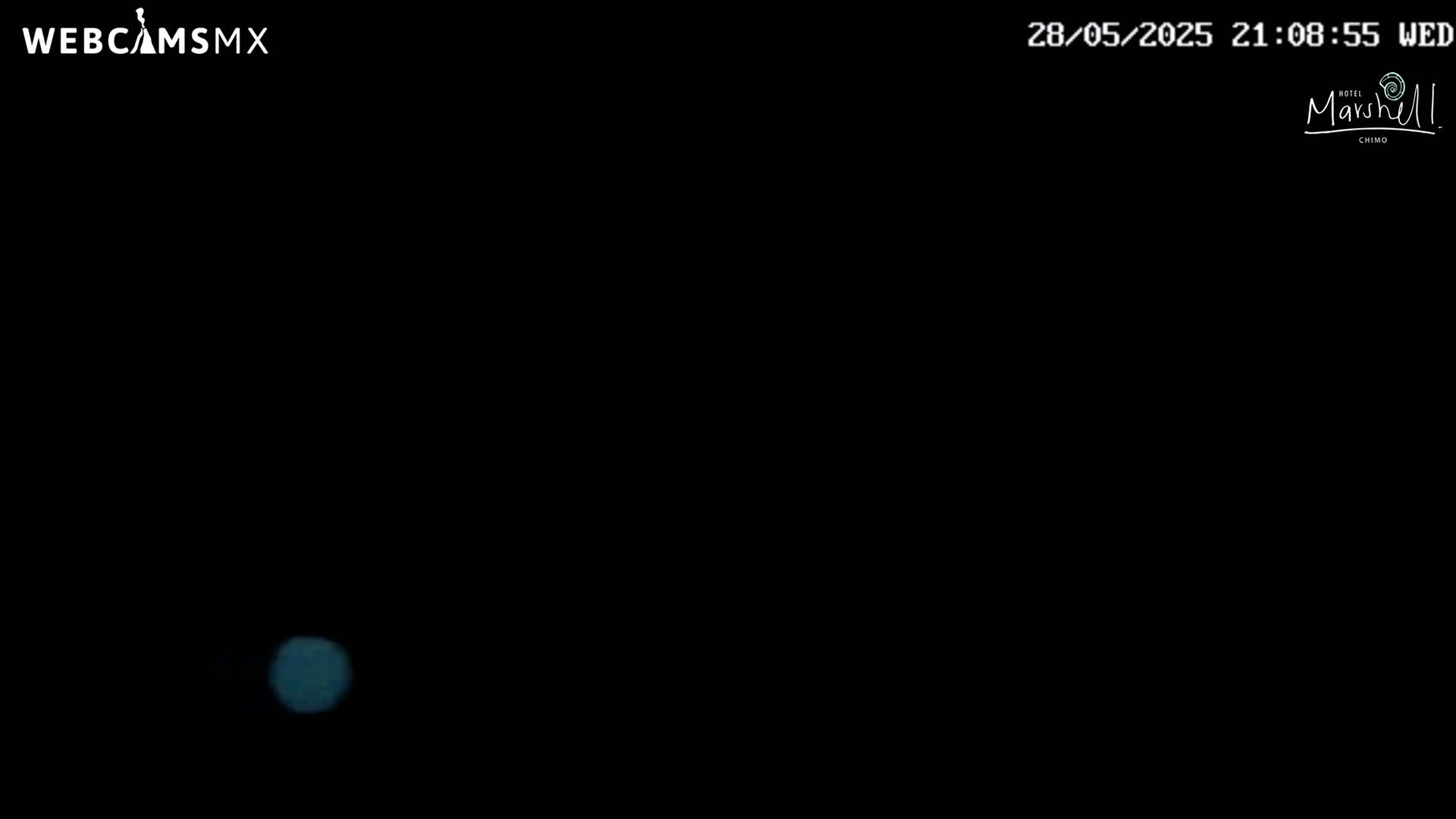 A single, small, blurry, light-blue light is visible in an otherwise completely black nighttime scene.