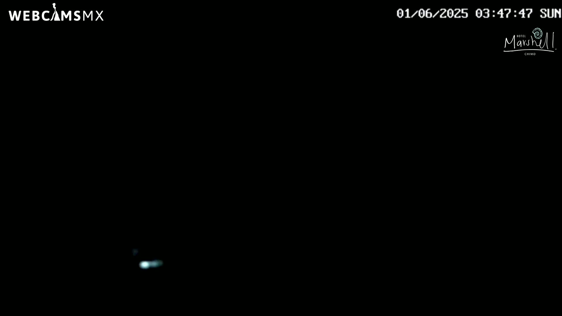A mostly black image shows a faint, blurry light source at the bottom center.