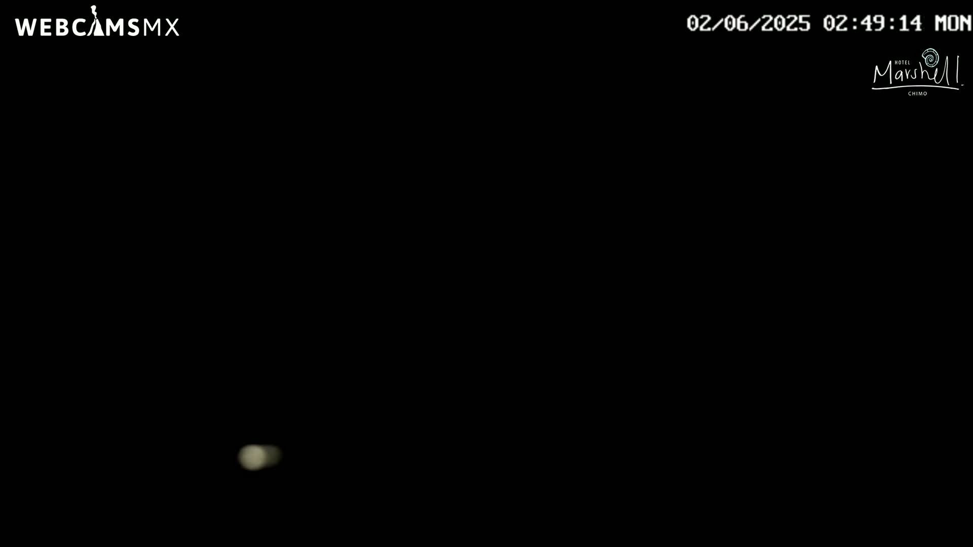 A faint, blurry light is visible in an otherwise completely black nighttime scene.