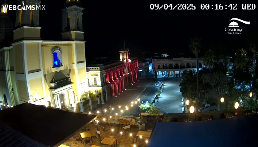 At night, a brightly lit plaza is shown with a large church and colonial-style buildings, illuminated with string lights.