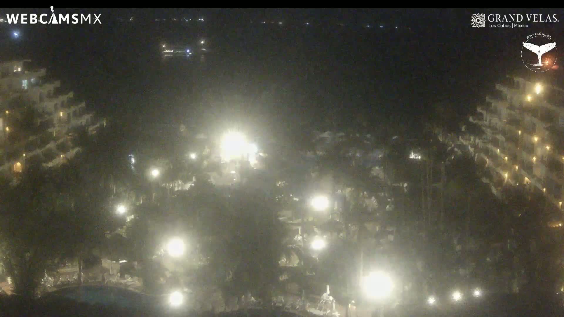 An aerial nighttime view of a resort with numerous lights illuminating buildings and landscaping.