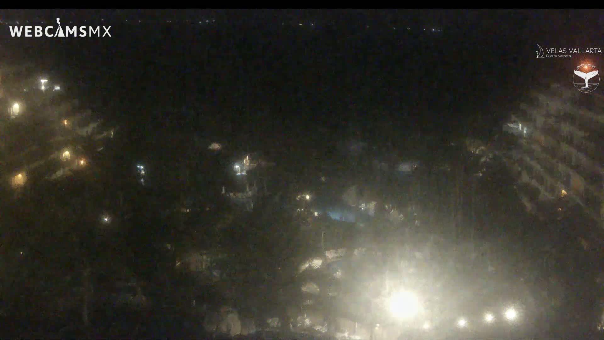 A nighttime aerial view of a resort area showing dimly lit buildings and landscaping.