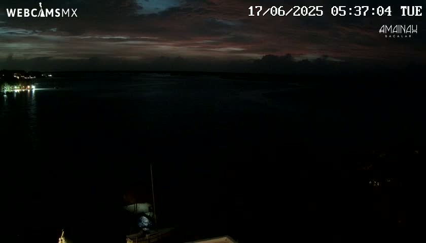 A dark body of water is visible under a dusky, pre-dawn sky.