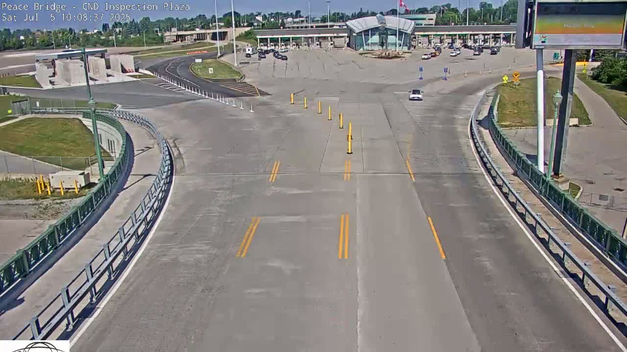 A mostly empty highway inspection plaza on a sunny day, with a few vehicles present.