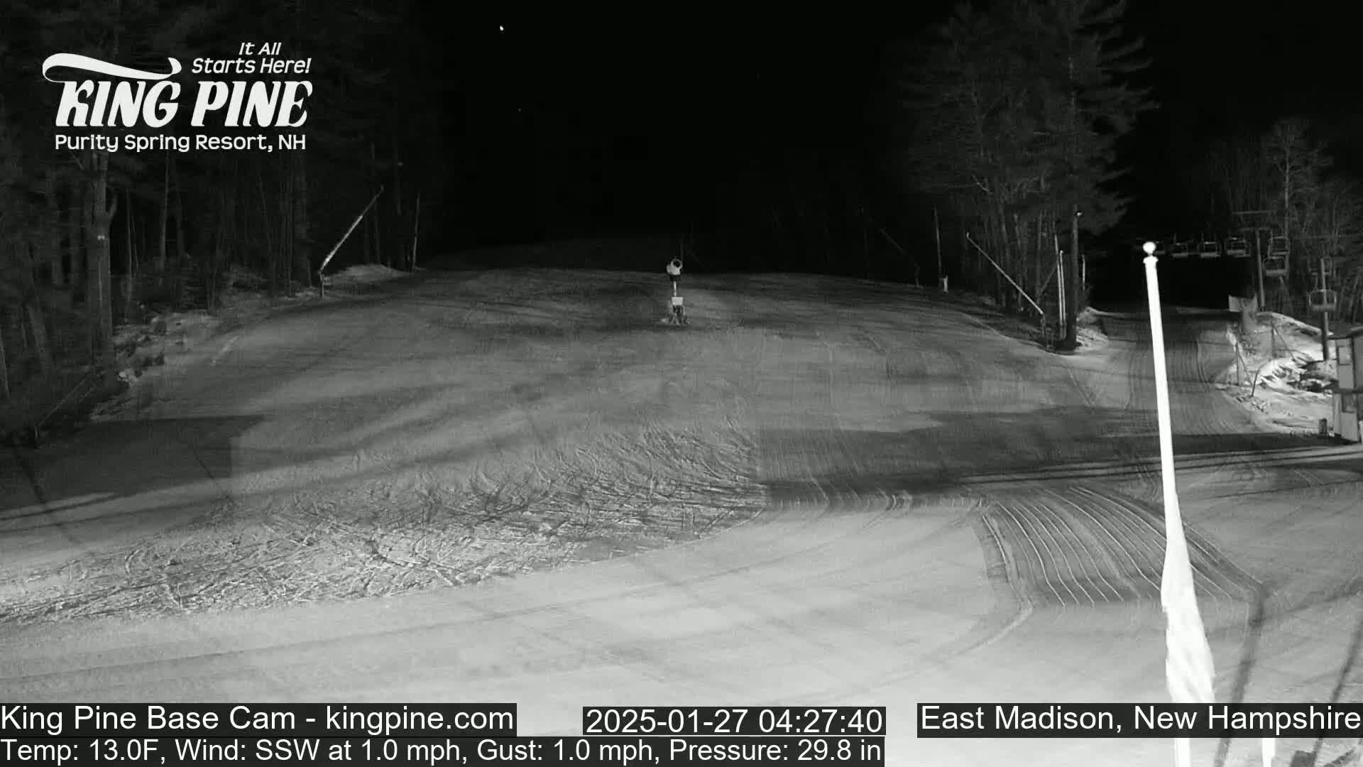 A nighttime, snow-covered ski slope is visible under a clear sky, with a light wind blowing from the south-southwest.
