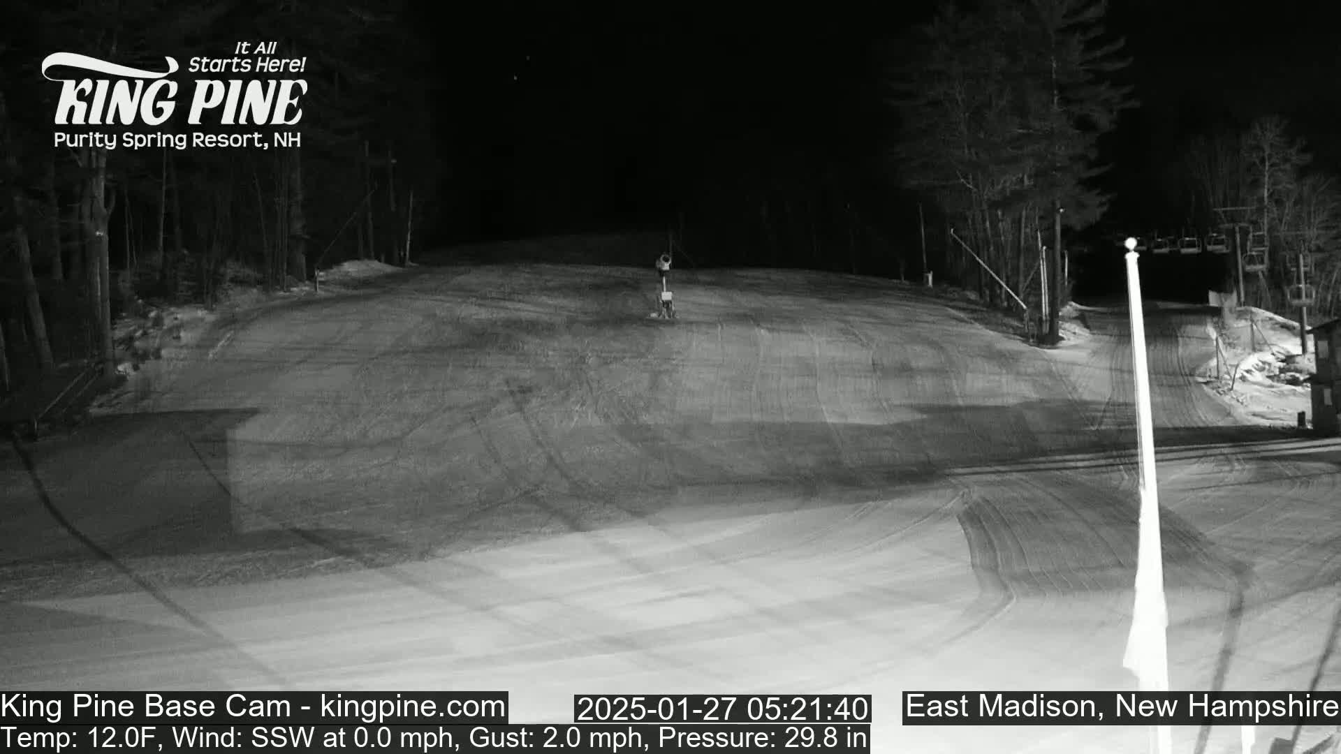 A nighttime, snow-covered ski slope is shown, with calm winds and a temperature of 12 degrees Fahrenheit.
