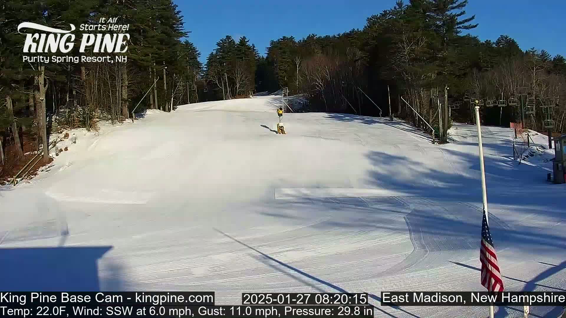 A snow-covered ski slope on a sunny day with a light south-southwesterly wind.