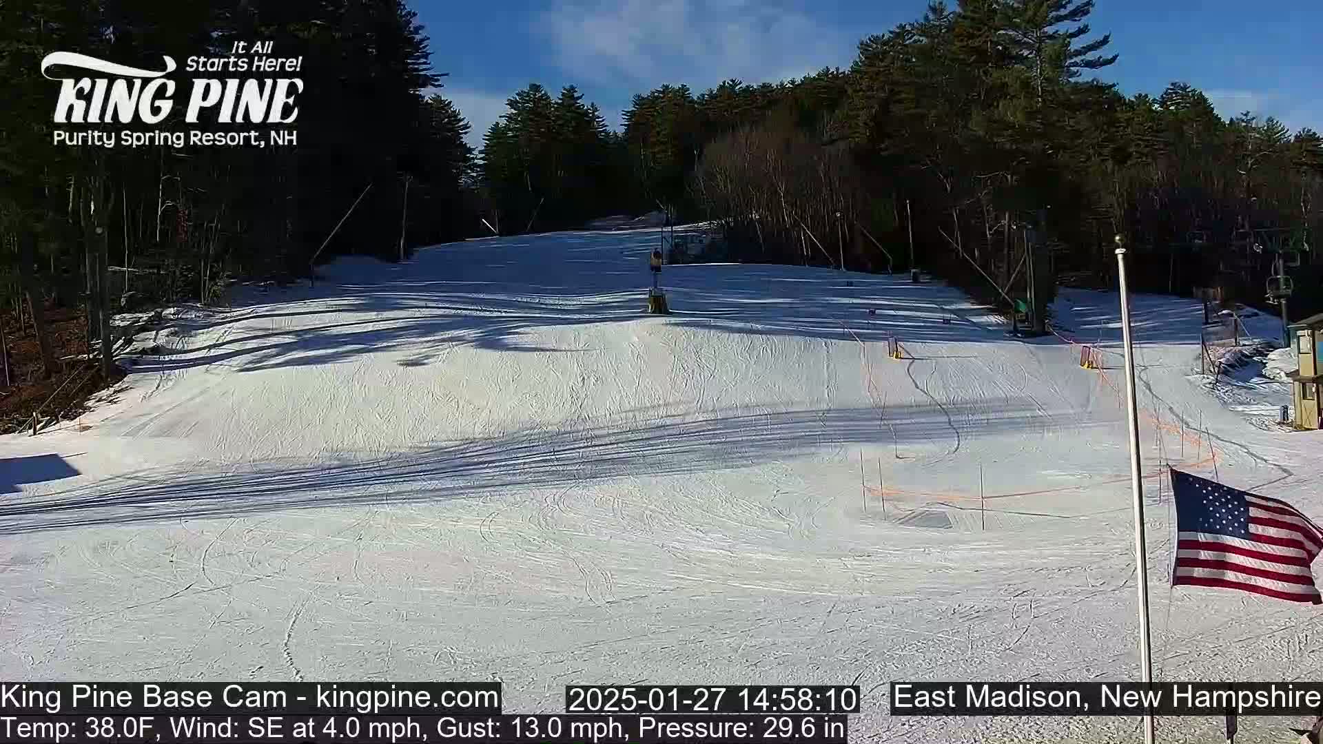 A snow-covered ski slope is visible on a sunny day with a light southeast wind.