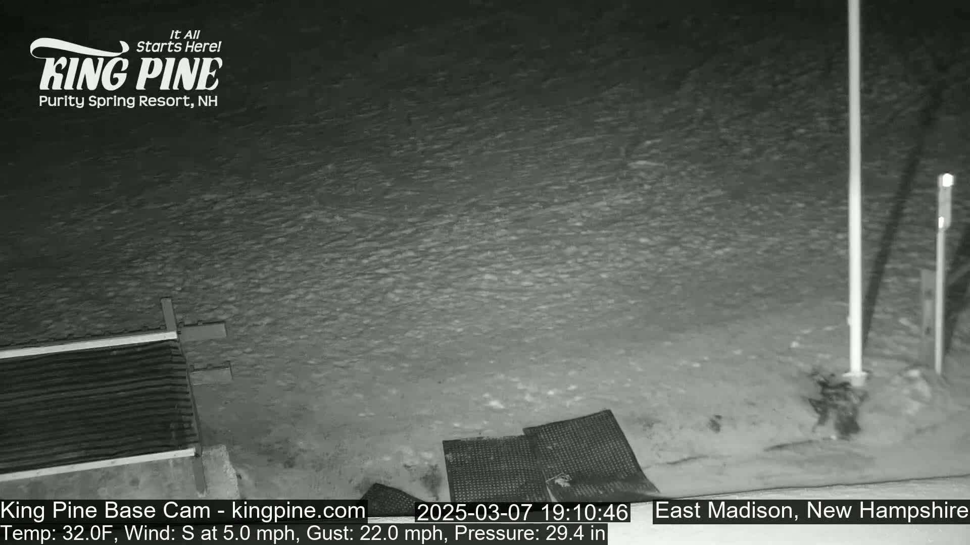 A snow-covered ground is visible at night, with a slight wind blowing.