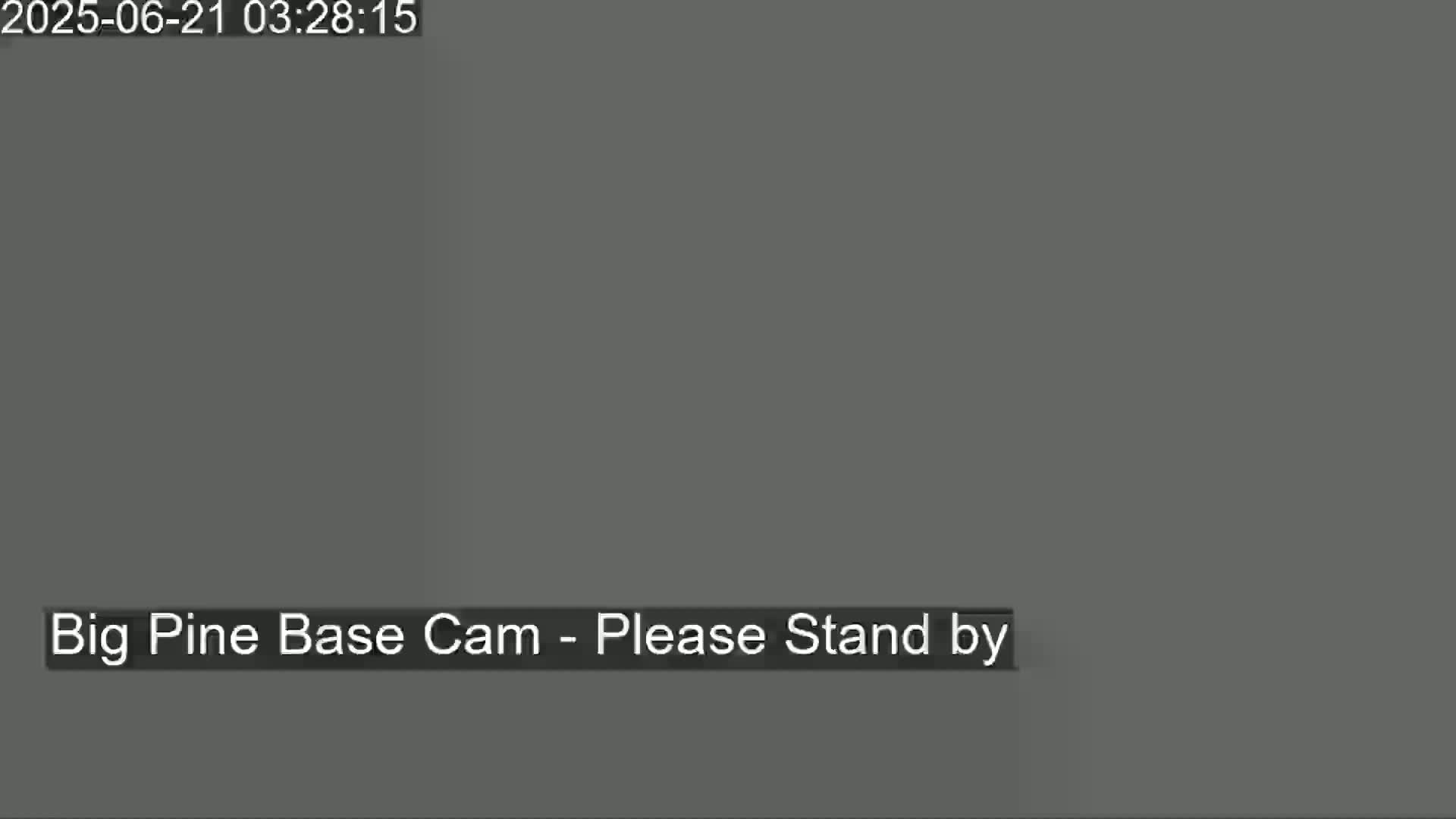 The image shows a solid dark gray screen with the message "Please Stand By".