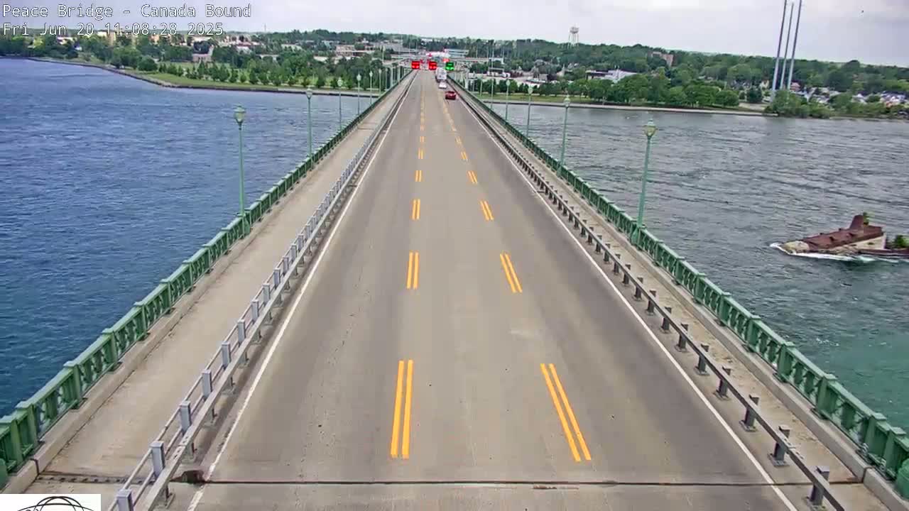 A long bridge with a few cars on it stretches over a body of water on an overcast day.