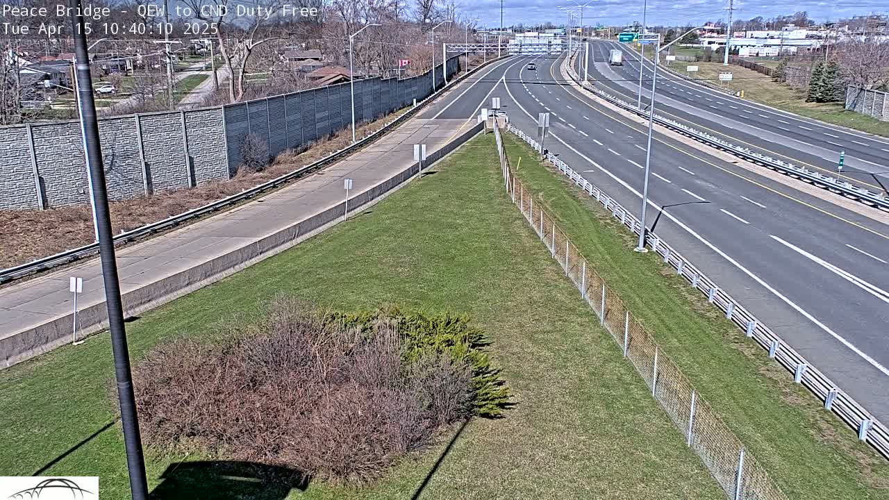 A highway with a few cars driving on a sunny day.