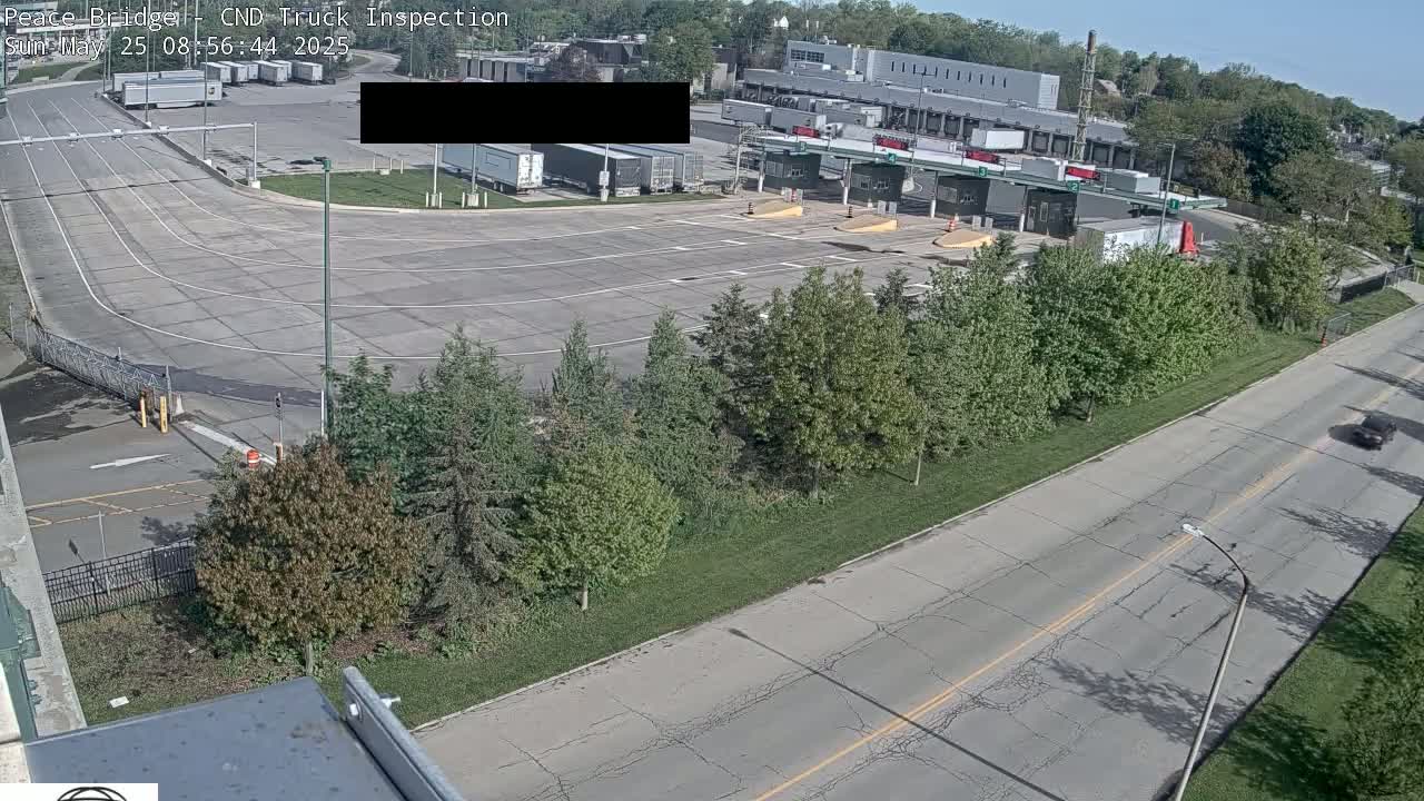 A truck inspection station with several semi-trucks parked nearby on a sunny day.