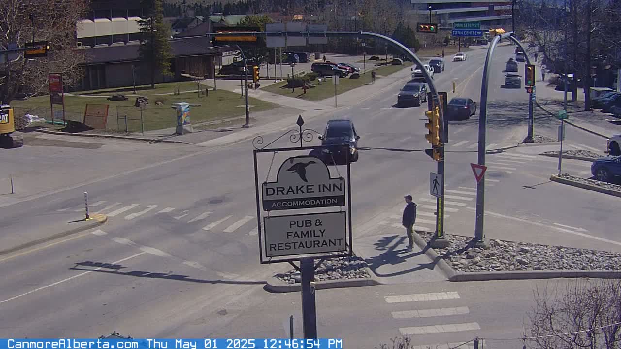 A sunny street scene shows a crossroads with several vehicles, a pedestrian crossing, and a Drake Inn sign.