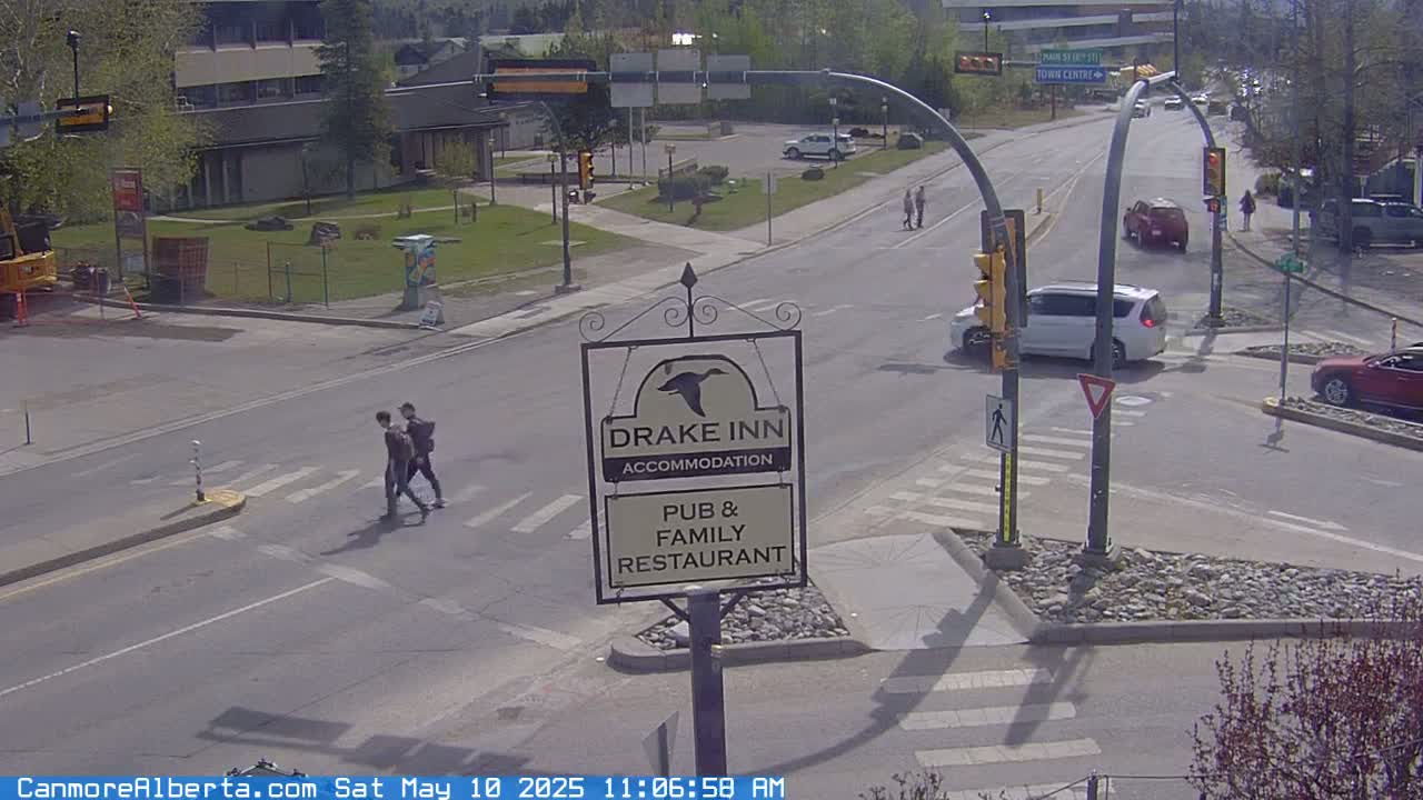 A sunny street intersection shows cars and pedestrians, with a Drake Inn pub and family restaurant sign visible.