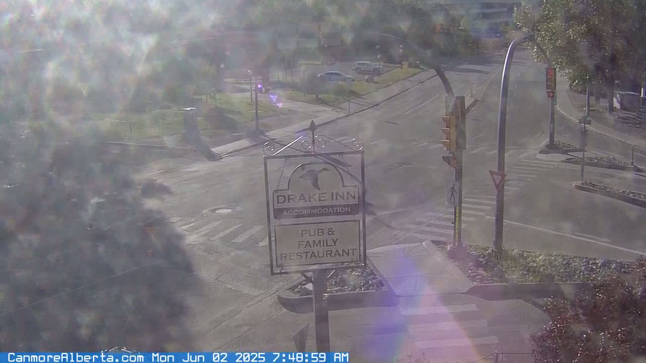 A hazy, sunny day reveals a street intersection with a Drake Inn sign, indicating a pub and family restaurant with accommodation.