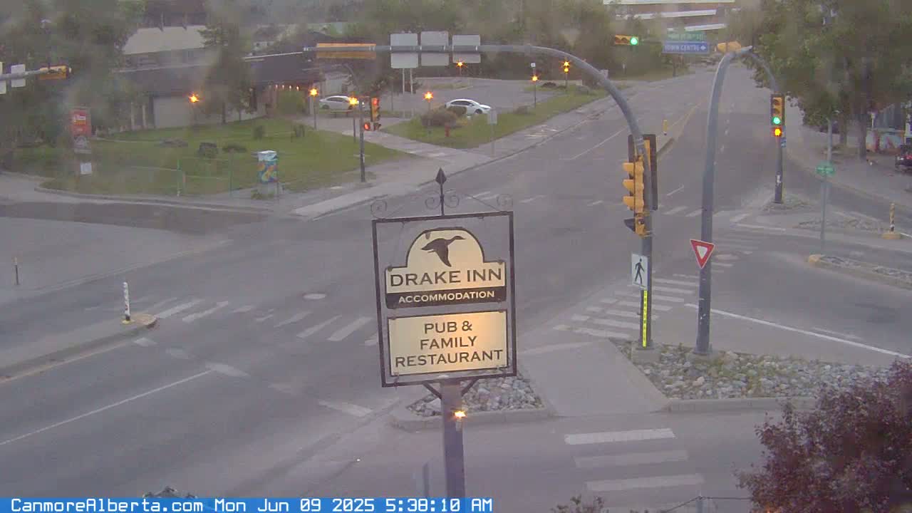 A street intersection with traffic lights and a Drake Inn pub and family restaurant sign is visible on an overcast day.