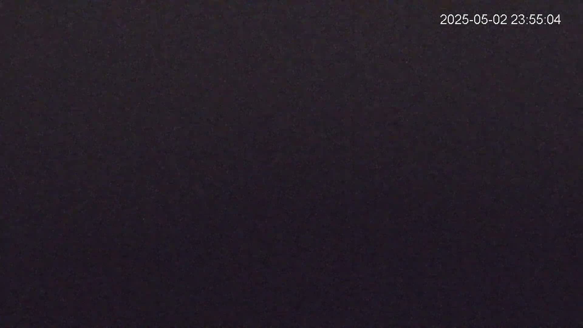 The image shows a completely dark, uniformly textured surface at night.