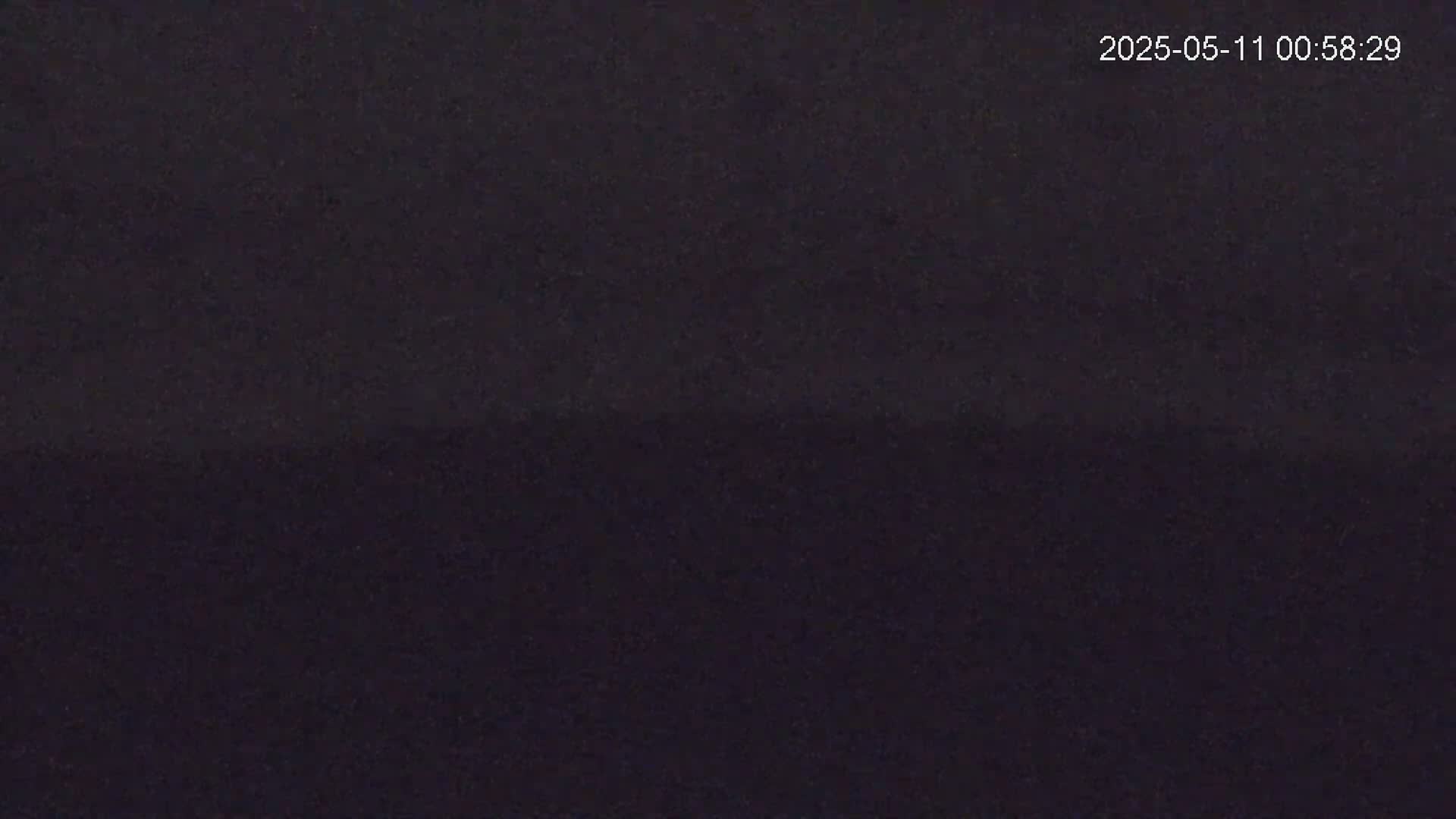 A dark, uniformly colored image shows a mostly featureless, possibly nighttime scene.