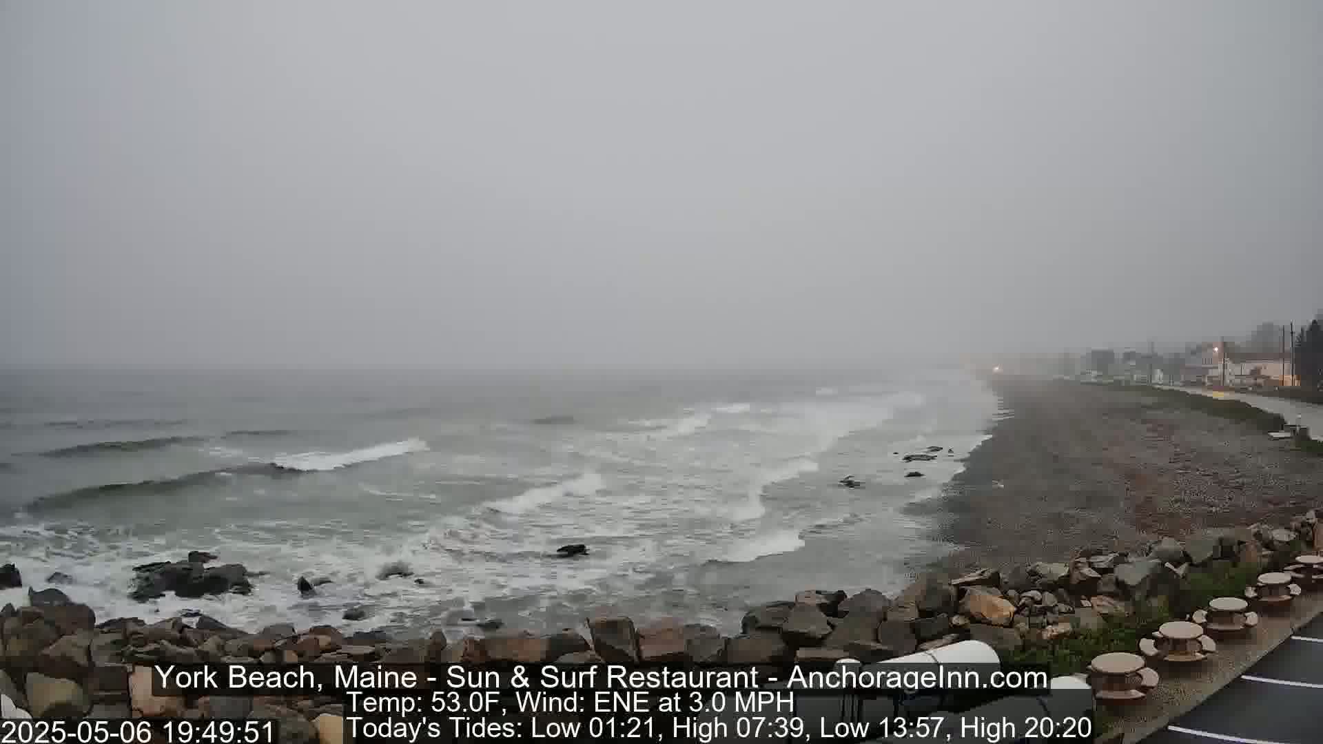 A rocky shoreline with gray, choppy waves under an overcast sky.