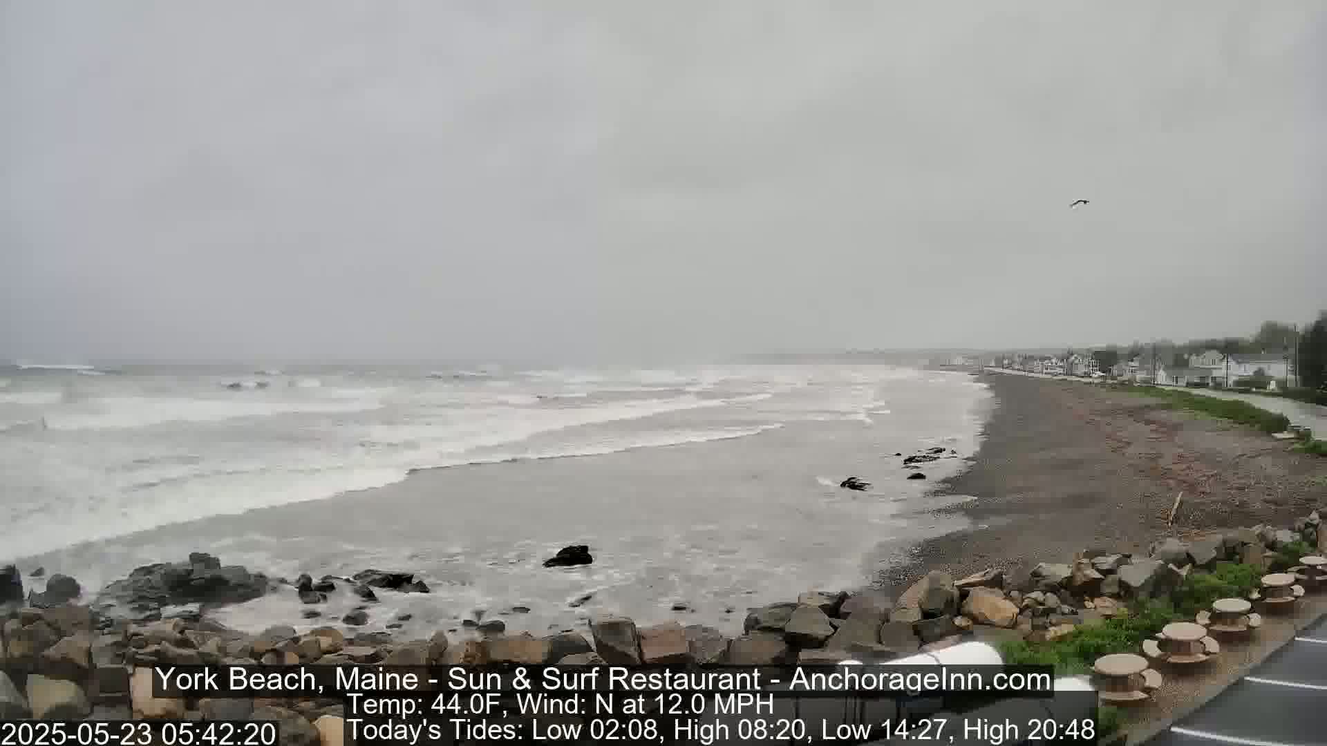 A rocky beach with moderate waves under an overcast sky.