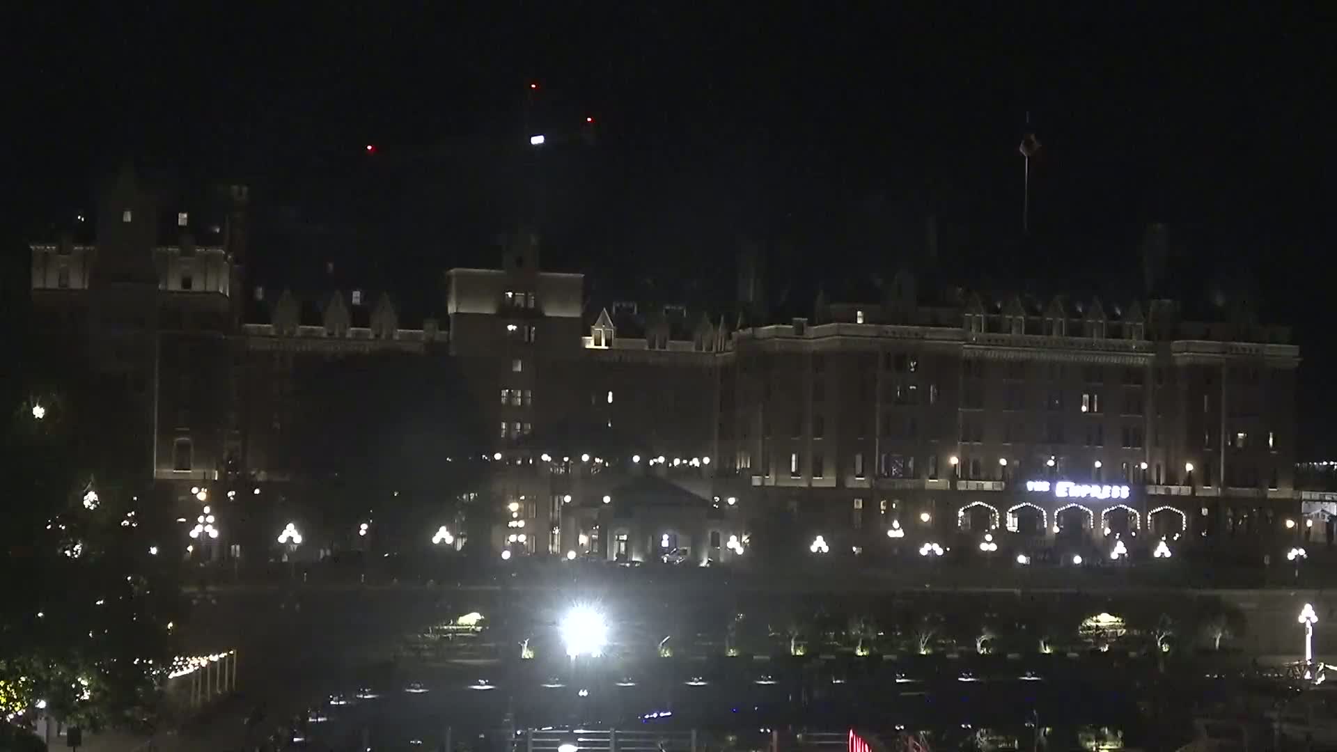 A large, illuminated hotel stands at night under a dark sky.