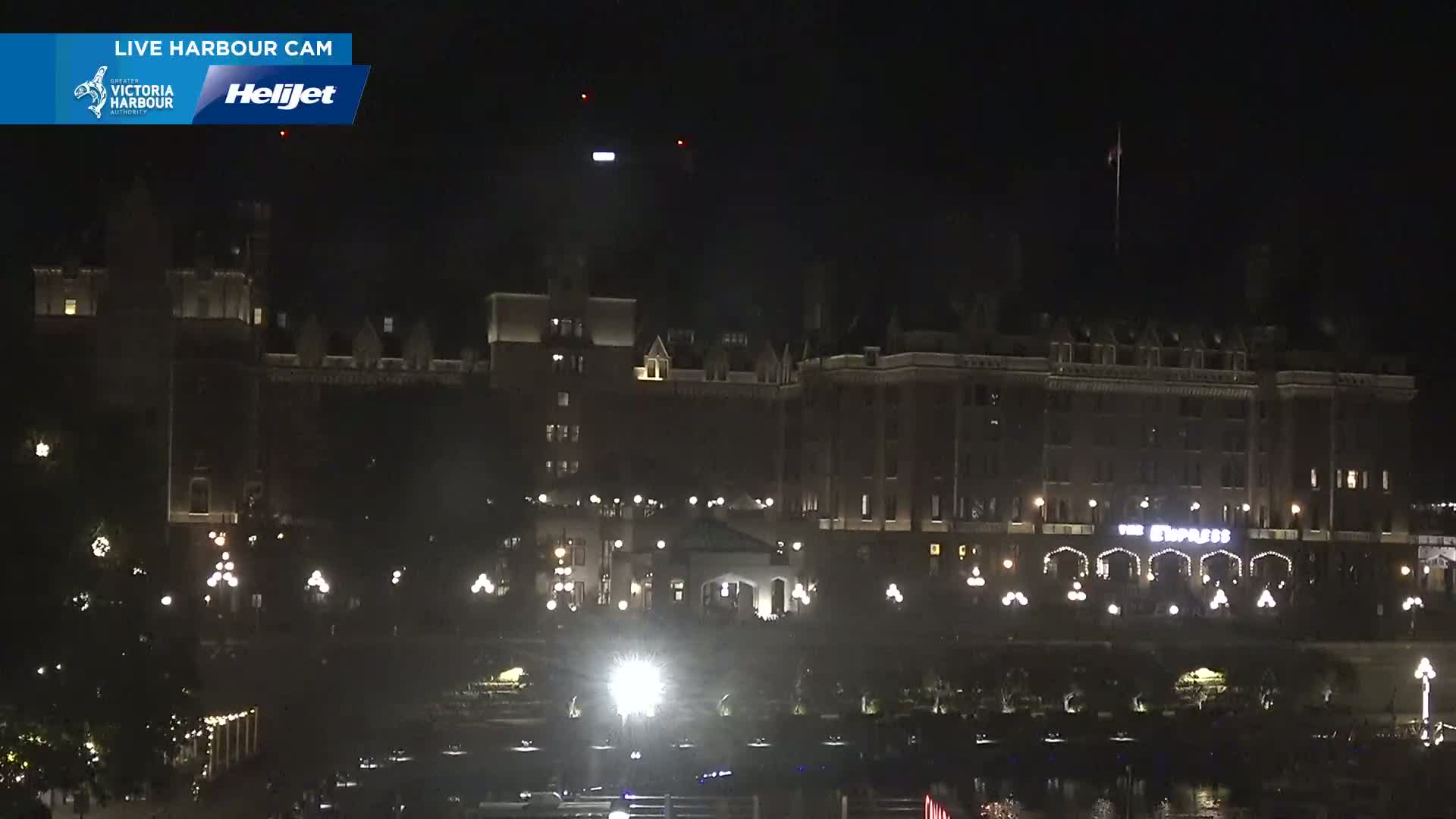A large, dark building with lights illuminating its facade is visible at night.