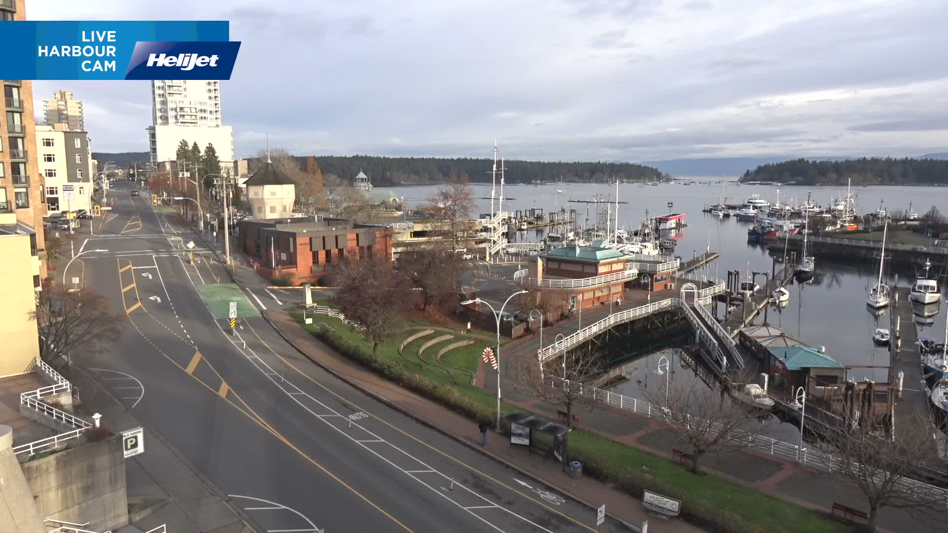 A nighttime, high-angle view shows a mostly empty street intersection with a white, octagonal tower and a building illuminated by streetlights.