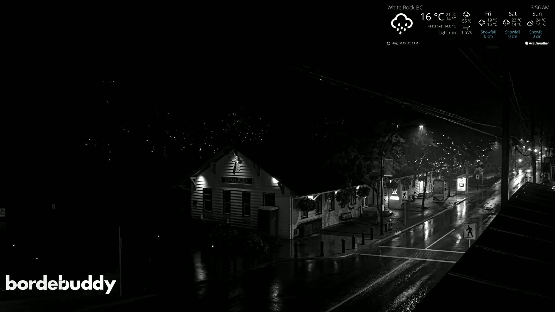 A mostly cloudy night scene shows a street with a building illuminated, some pedestrians, and string lights in the trees.