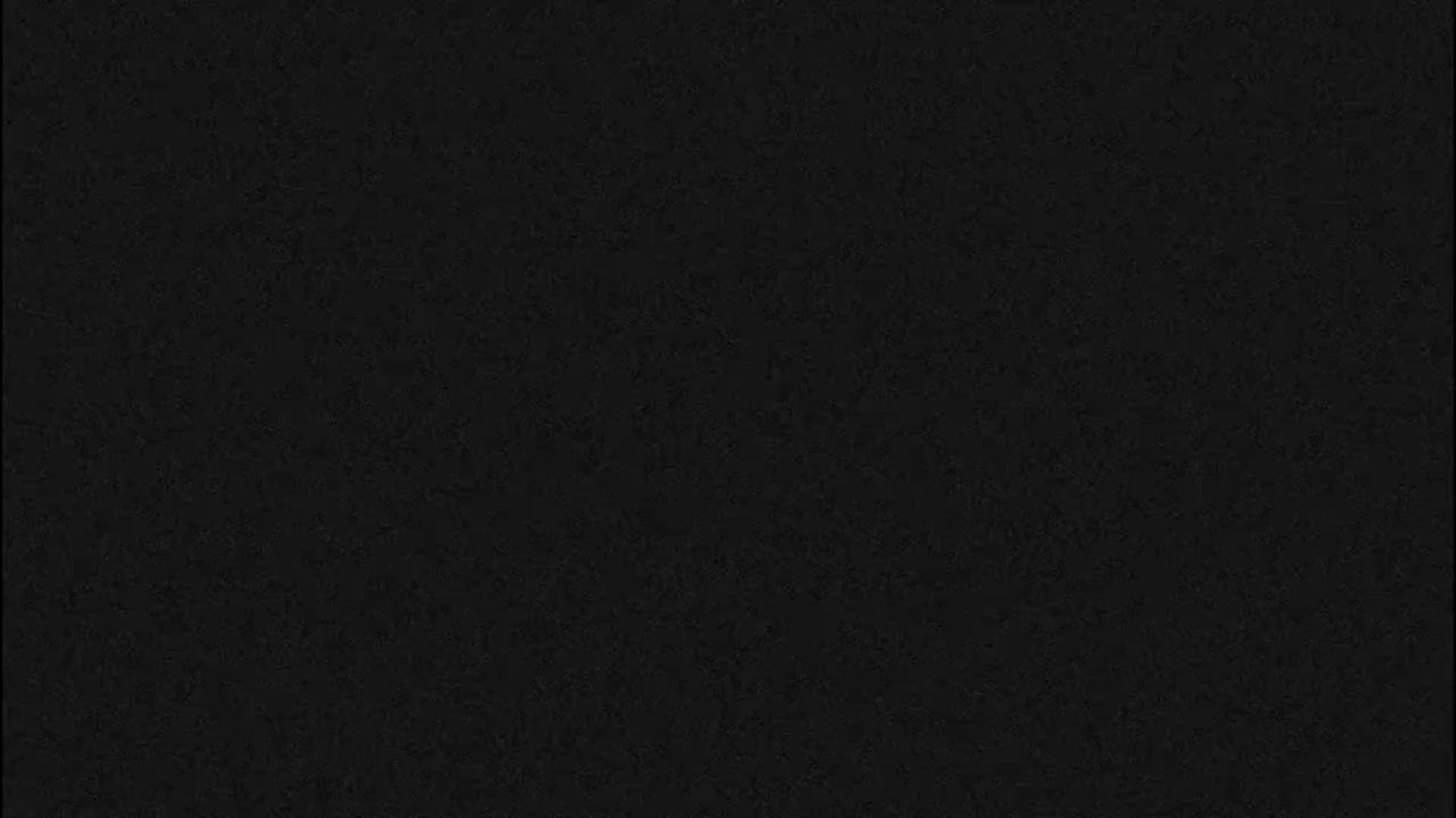 The image displays a uniformly dark, finely textured black or very dark gray surface.