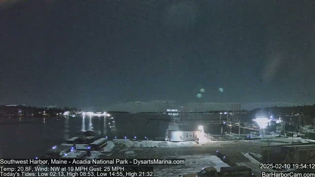 A nighttime harbor scene with snow on the ground, under a clear, dark sky, and a northwest wind.