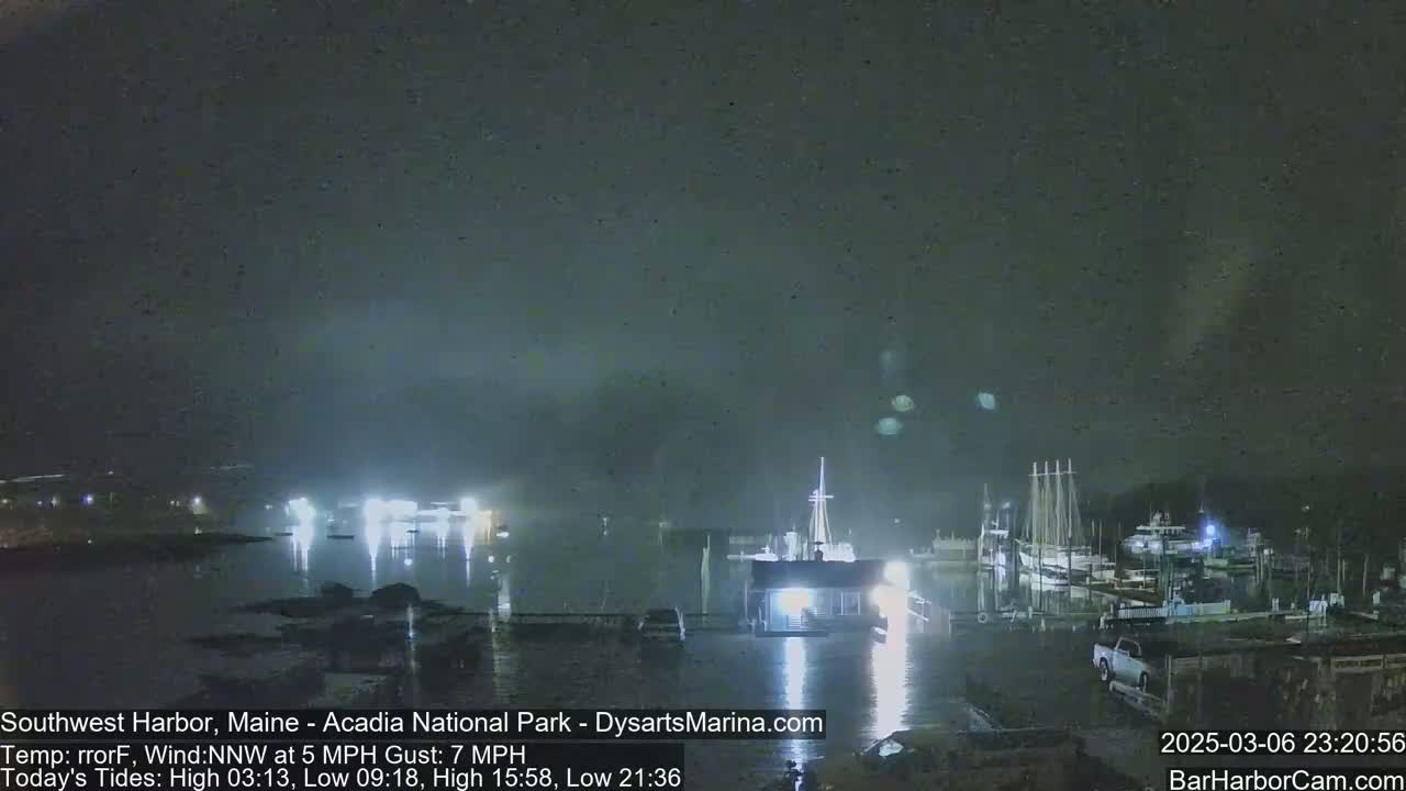 A nighttime view of a harbor with boats docked under a dark, overcast sky.