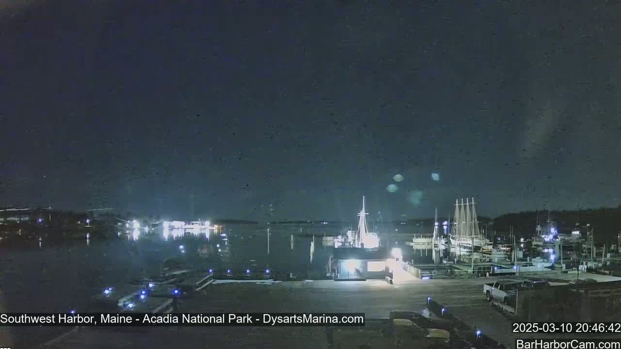 A nighttime view of a harbor with docked boats under a clear, dark sky.