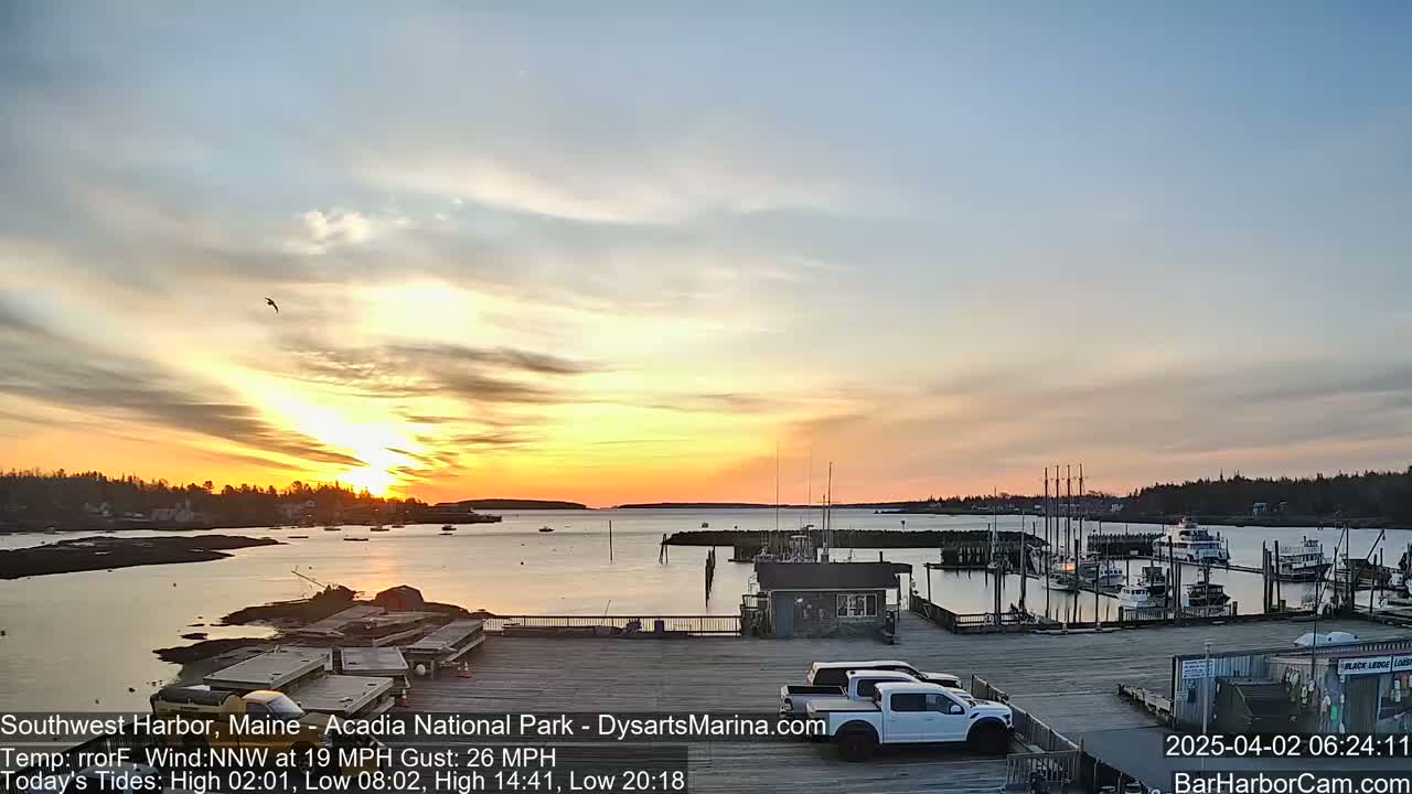 A harbor filled with boats at sunset under a partly cloudy sky.