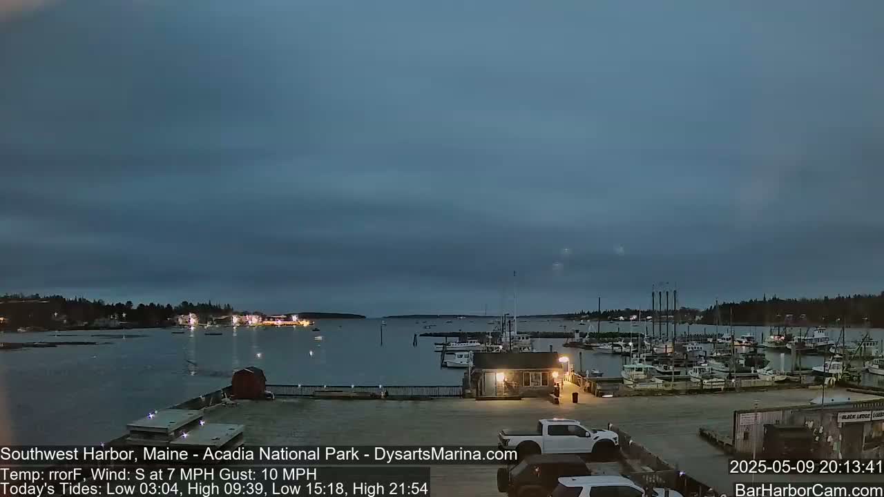 A harbor filled with boats at dusk under a cloudy sky with a gentle south wind.