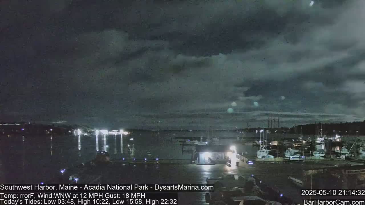 A nighttime harbor scene under a dark, cloudy sky with a southwest wind.