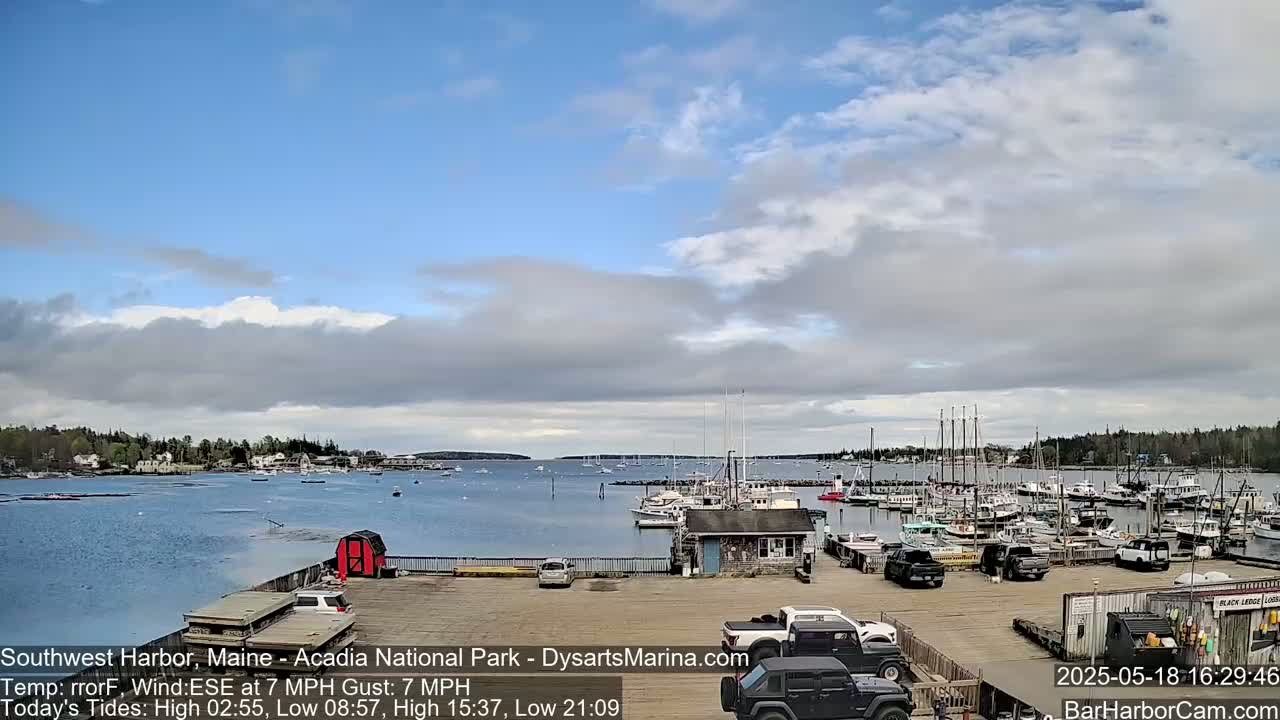 A harbor filled with numerous boats under a partly cloudy sky.