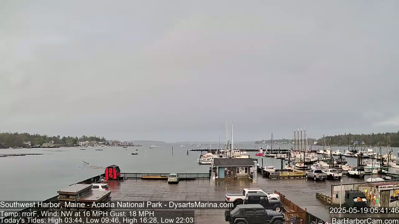 A harbor filled with numerous boats is shown under an overcast sky, with a northwest wind.
