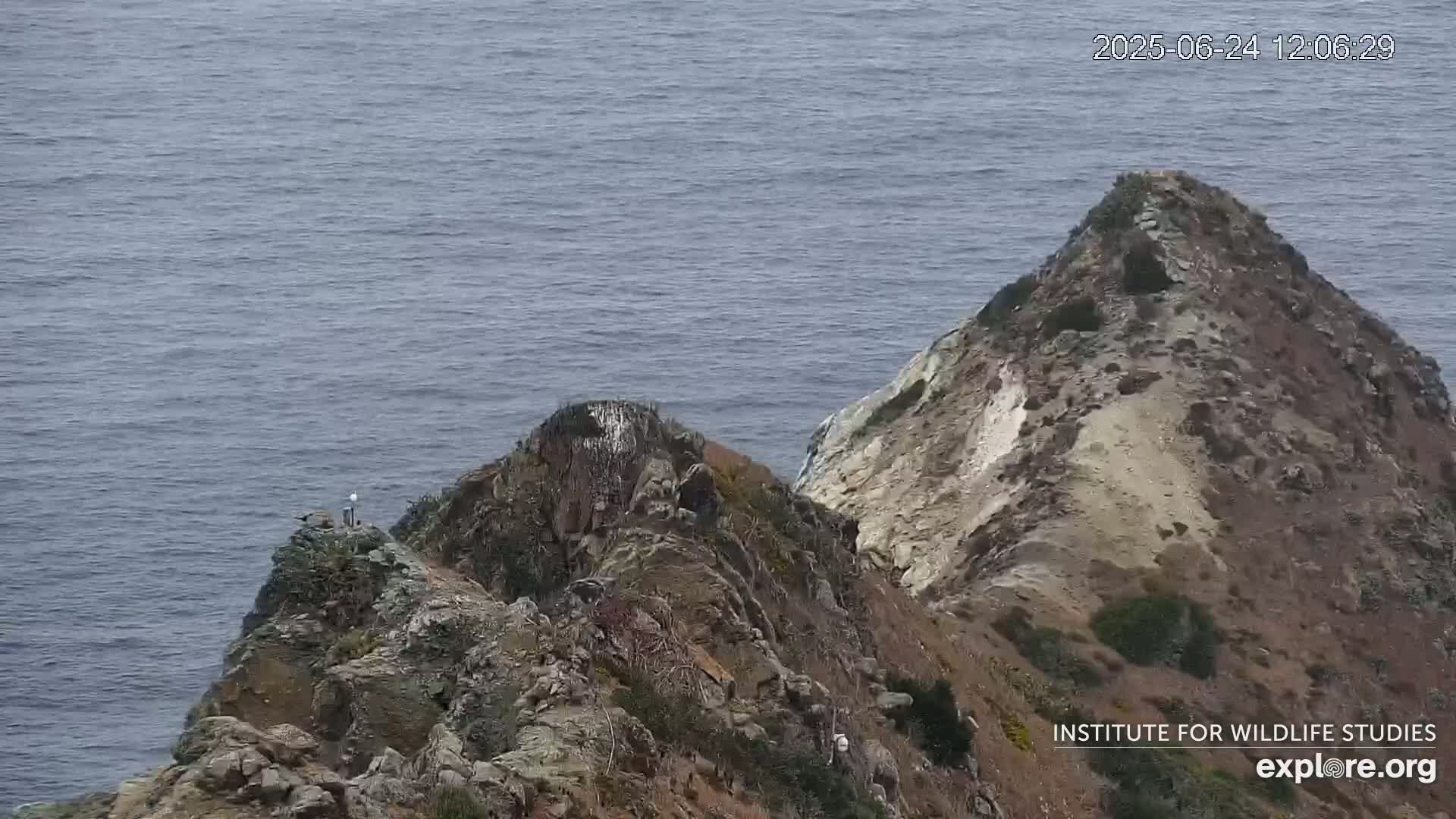 Two rocky peaks jut out into a calm ocean.