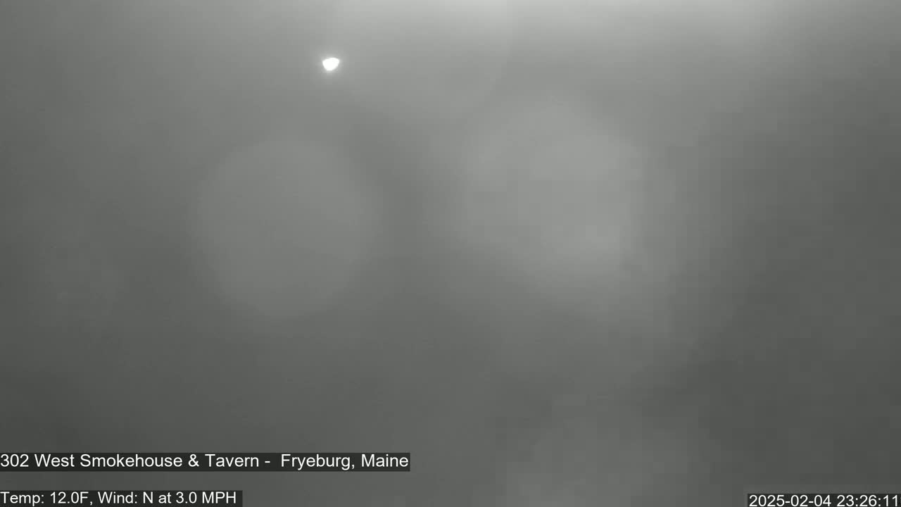 A dimly lit, foggy scene is visible, with a faint light source in the upper portion of the frame.