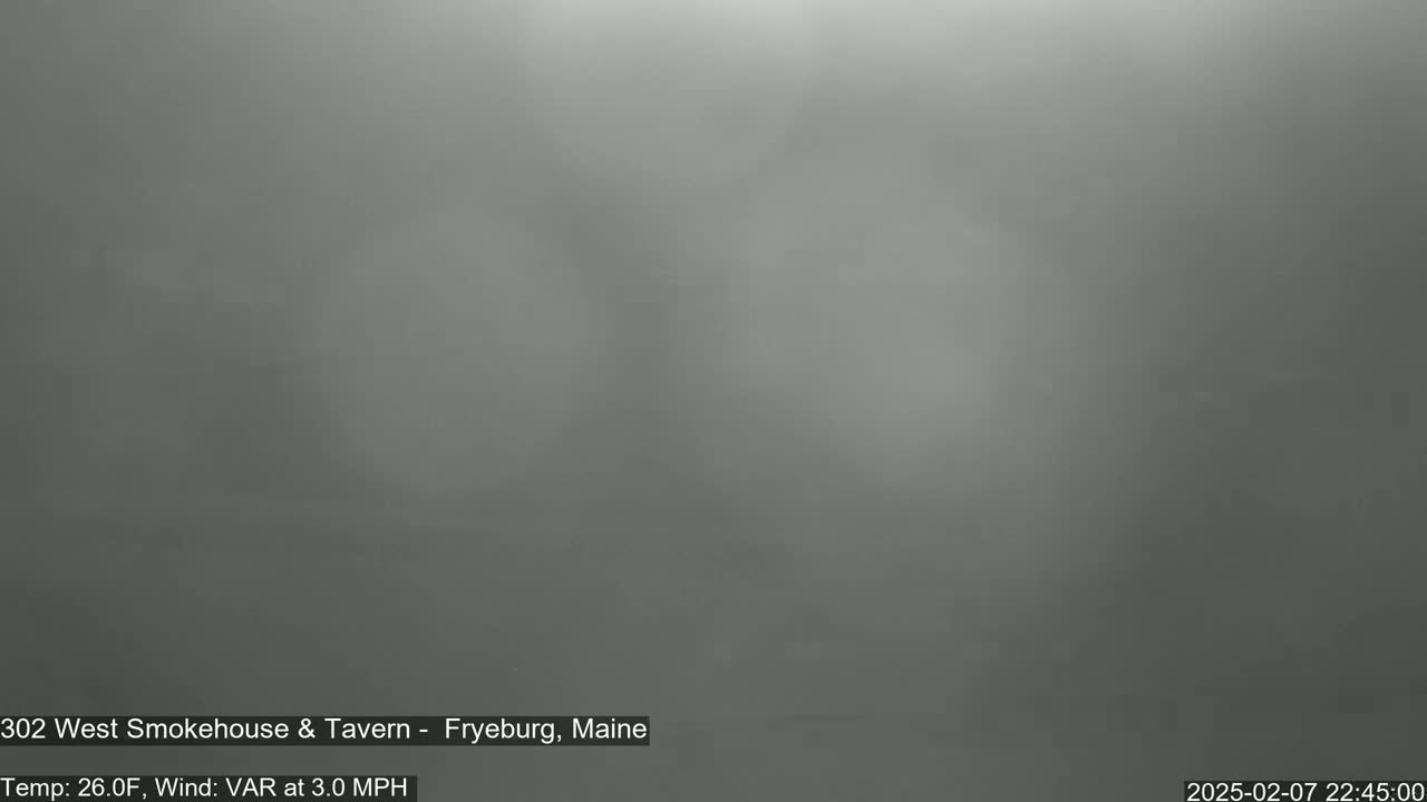 A blurry, gray image shows an overcast night sky with a temperature of 26 degrees Fahrenheit and a variable wind at 3 miles per hour.