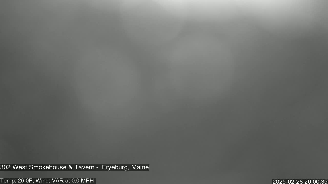 A blurry, gray image shows a foggy or hazy outdoor scene with calm winds and a temperature of 26 degrees Fahrenheit.