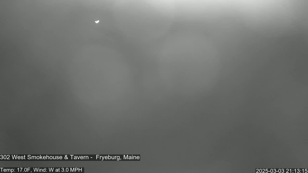 A partially obscured sun is visible in a hazy, gray sky.