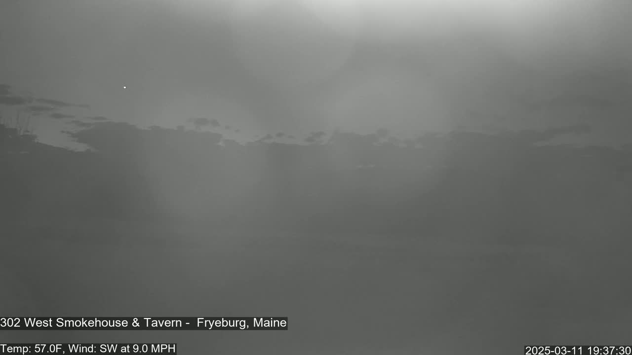 A hazy, overcast sky is visible over a dark landscape with a southwest wind at 9.0 mph and a temperature of 57°F.